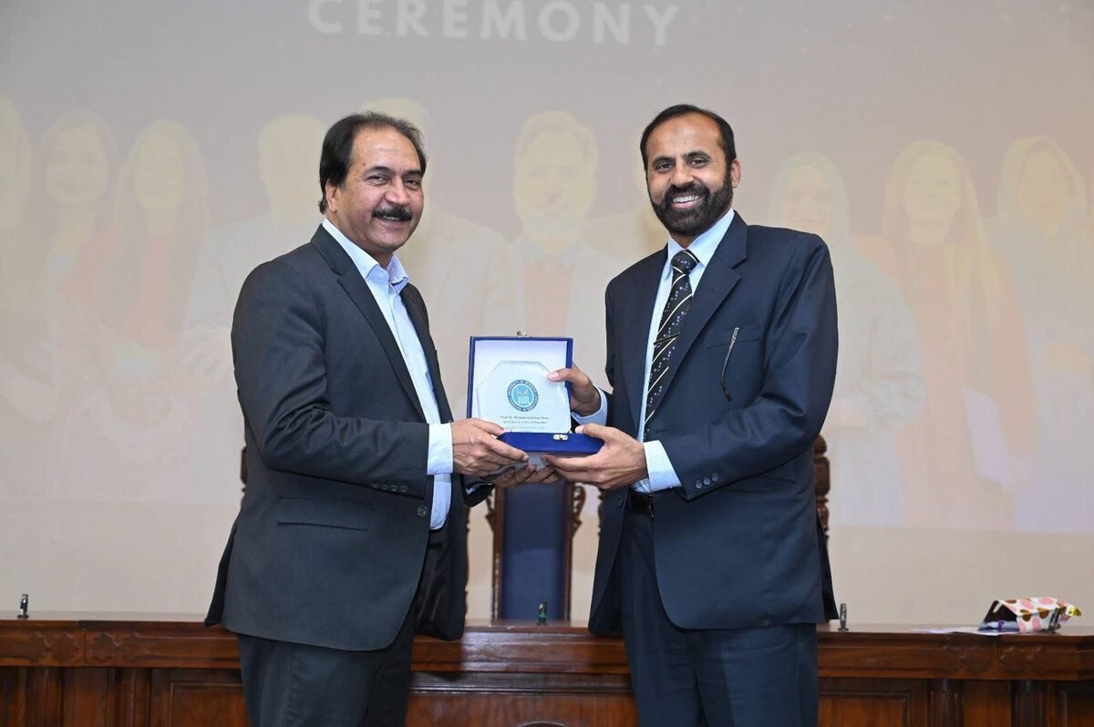 Dr. Muntazar Mehdi receiving a recognition shield at a NUML ceremony
